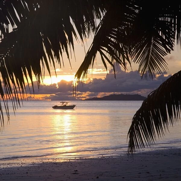 Small boat moored off the beach at Anse Volbert at sunrise, Baie Sainte Anne district