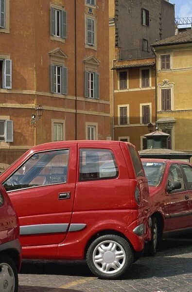 Small red car parked in square off Via Giulia