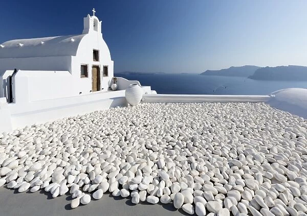 Small whitewashed church against blue sea and sky, Finikia, near Oia, Santorini, Cyclades