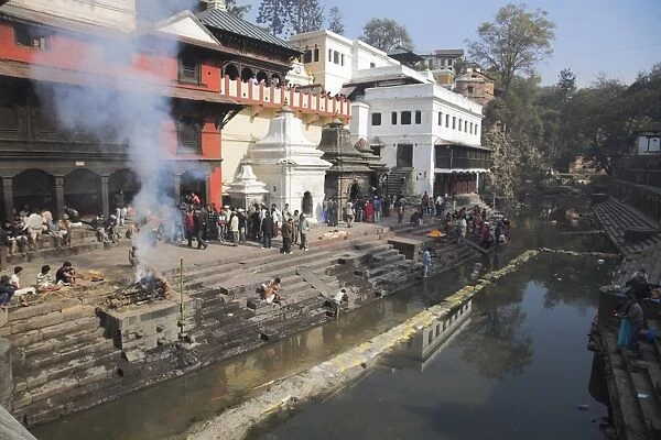 Smoke rising from cremation ceremony on banks of Bagmati River during Shivaratri festival