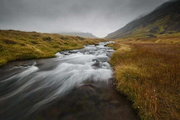 Snaefellsness, National Park, Glacial river flowing through mossy tundra, Iceland
