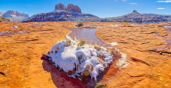Snow covered Cathedral Rock in Sedona viewed from a sandstone plateau along Secret Slick