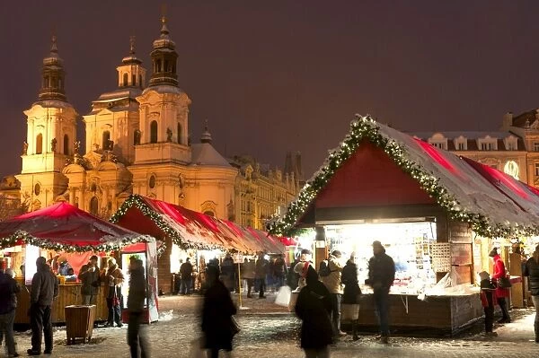 Snow-covered Christmas Market and Baroque St. Nicholas Church, Old Town Square, Prague, Czech Republic, Europe