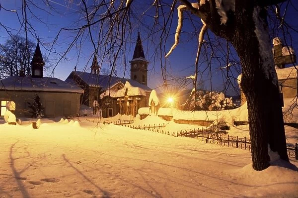 Snow-covered graveyard and Catholic church in village of Luceny nad Nisou