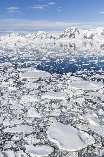 Snow-covered mountains line the ice floes in Penola Strait, Antarctica, Polar Regions