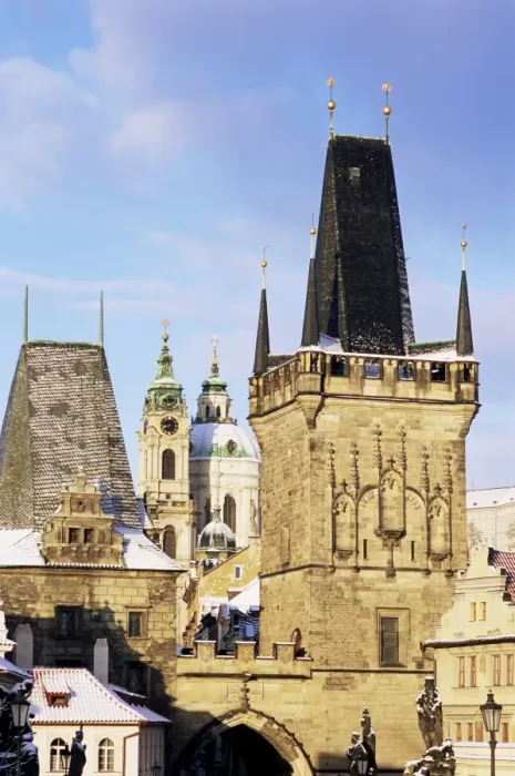 Framed Print : Snow-covered Romanesque and Gothic Malostranske Bridge towers and in the background the towers of the Baroque St. Nicholas church, Mala Strana, Prague, Czech