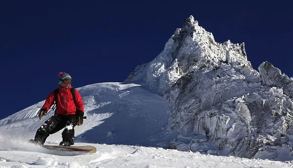 A snowboarder riding powder snow off the top of the famous Grand Montets ski area