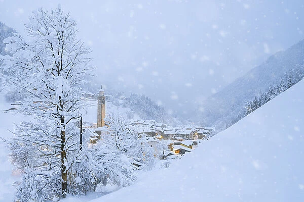 Snowflakes falling on mountain huts in the fairy tale alpine village at Christmas time