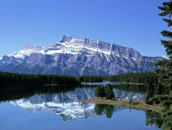 Snowy peak of Mount Rundle reflected in the water of Two Jack Lake, Banff National Park