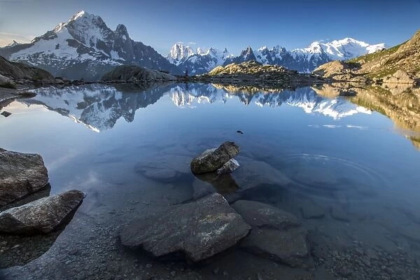 Snowy peaks of Aiguilles Verte, Dent Du Geant, and Mont Blanc are reflected in Lac Blanc