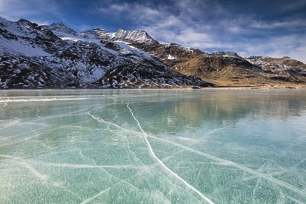 The snowy peaks frame the frozen turquoise water of White Lake (Lago Bianco), Bernina Pass