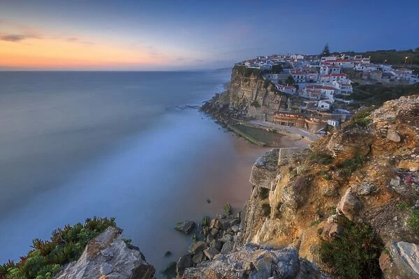 The soft colors of twilight frame the ocean and the village of Azenhas do Mar, Sintra