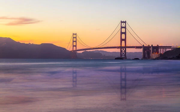 Soft flowing water reflects the beautiful Golden Gate Bridge at sunset, San Francisco