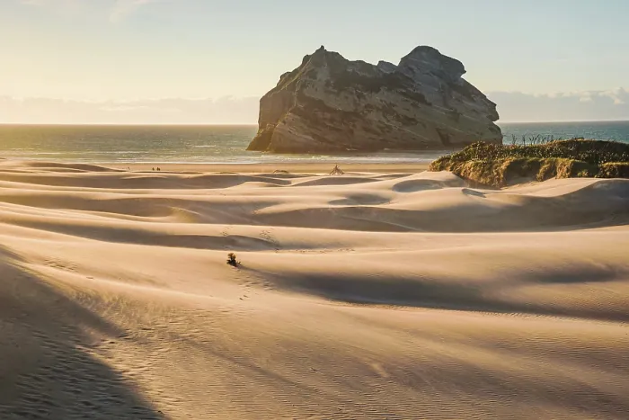 Framed Print : Solitary Walker Across Vast Dunes with Archway Island at Sunrise, Wharariki Beach, New Zealand