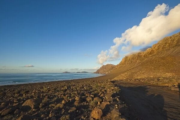 Spectacular 600m volcanic cliffs of the Risco de Famara and Graciosa Island at the northern end of Lanzarotes finest beach at Famara, Lanzarote, Canary Islands, Spain, Atlantic