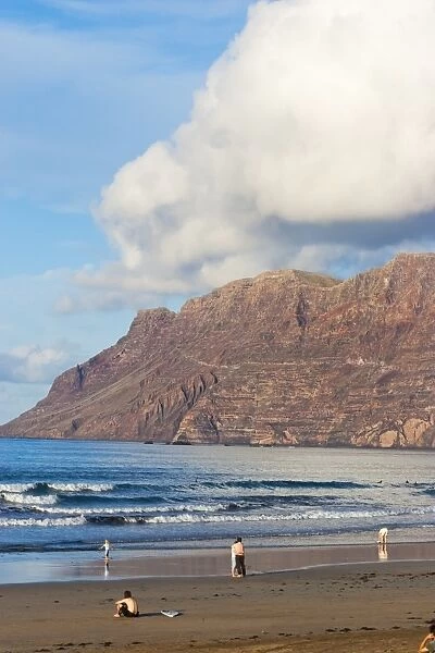 Spectacular 600m volcanic cliffs of the Risco de Famara rising over islands finest surf beach in the north west of the island, Famara, Lanzarote, Canary Islands, Spain, Atlantic
