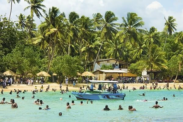 Sri Lankans swimming at the west end of this popular resort and beach, wrecked by the 2004 tsunami, Unawatuna, Galle, Sri Lanka, Asia