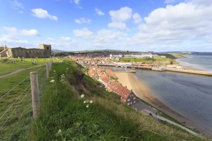 Framed Print : St. Marys Church and churchyard with view across Tate Hill Beach and town houses to West Cliff Framed Print : St. Marys Church and churchyard with view across Tate Hill Beach and town houses to West Cliff