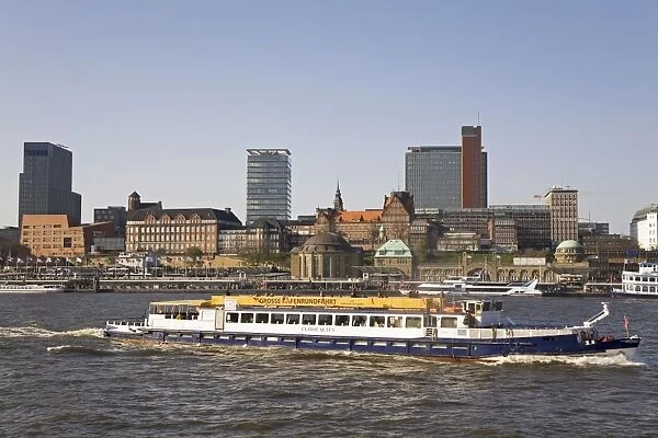The St. Pauli skyline is seen behind a ship giving a guided tour of the port of Hamburg