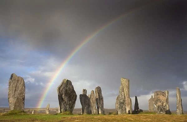 Standing Stones of Callanish bathed in sunlight with a rainbow arching across the sky in the background, near Carloway, Isle of Lewis, Outer Hebrides, Scotland, United Kingdom, Europe