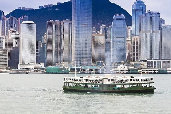 Star ferry crosses Victoria Harbour with Hong Kong Island skyline behind, Hong Kong, China, Asia