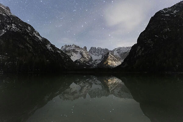 Starry sky over Cristallo group mountains reflected in Lake Landro, Dolomites