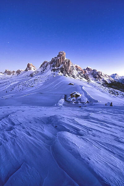 Starry sky at dusk on Ra Gusela mountain surrounded by fresh snow, Giau Pass, Dolomites