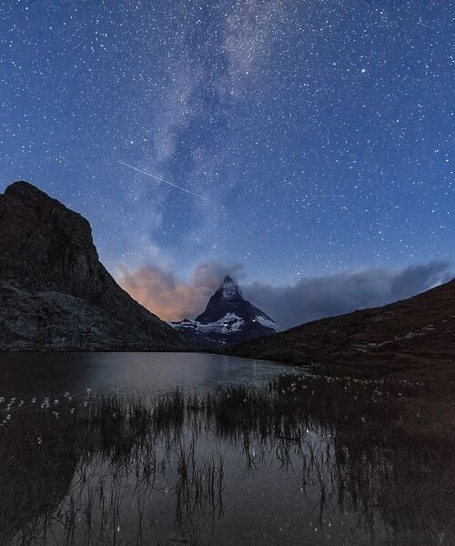 Stars and Milky Way above the Matterhorn reflected in Lake Stellisee, Zermatt, Canton of Valais