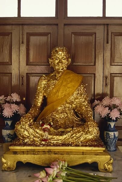 Statue covered in gold leaf in Buddhist temple