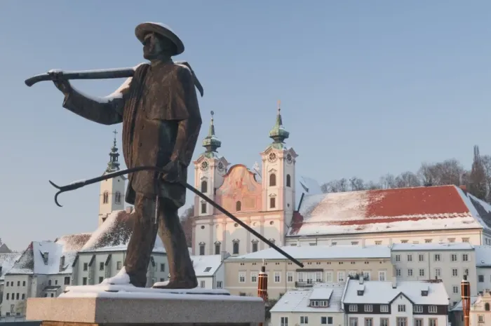Framed Print : Statue honouring townspeople and Baroque Michaelerkirche church dating from 1635 at sunset
