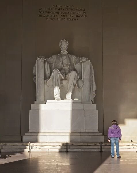 The statue of Lincoln in the Lincoln Memorial being admired by a young girl, Washington D. C. United States of America, North America
