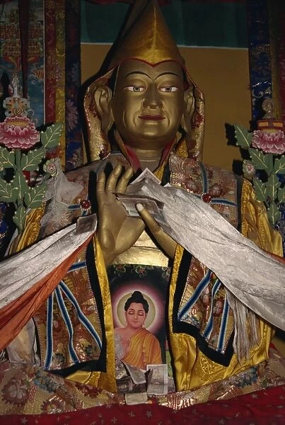 Statue with scarves and offerings of money in Ganden monastery, Tibet, China, Asia