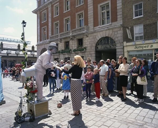 Statue street performer, and group of people watching, Covent Garden, London
