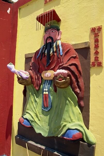 Statue on wall of the Chinese temple in Miri