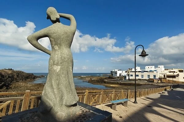 Statue of woman looking out to sea by the old harbour at this north west coast village, El Cotillo, Fuerteventura, Canary Islands, Spain, Atlantic, Europe