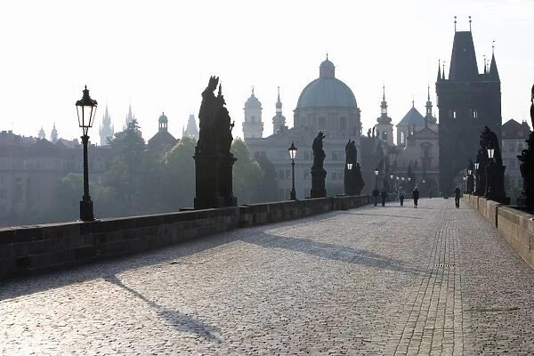 Statues on Charles Bridge, UNESCO World Heritage Site, with the dome of the Church of St