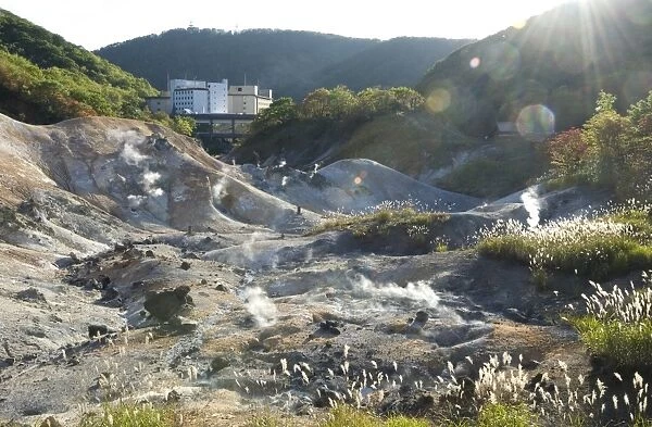 Steam vents in Jigokudani geothermal area, hotels of Noboribetsu Onsen beyond