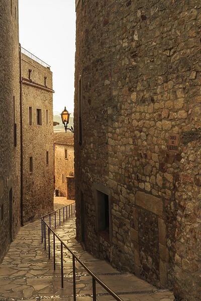 Steep and narrow winding street in gorgeous medieval hilltop walled village, Pals