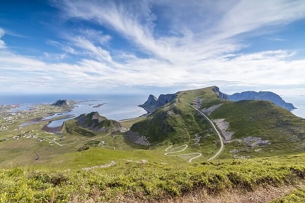 Steep road of curves in between green meadows and sea, Sorland, Vaeroy Island, county of Nordland