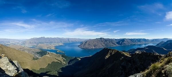 Steep sharp mountains, a deep blue lake, and mountain town in Queenstown, Otago, South Island