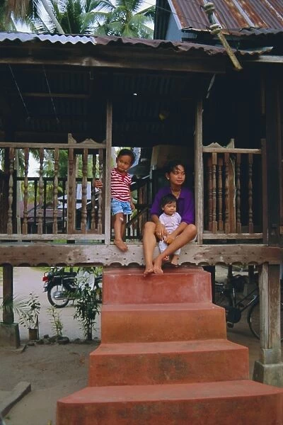 Stilt house and local family in traditional Malayan village