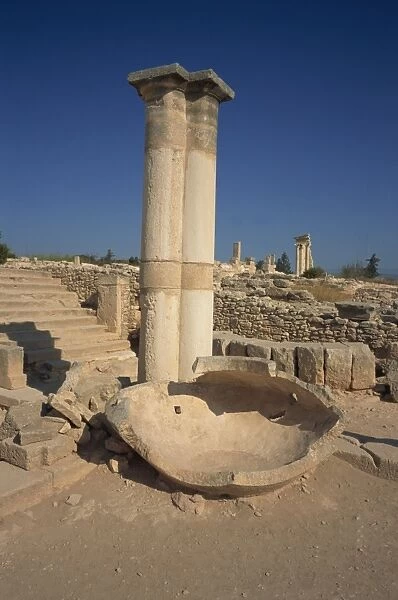 Stone pithos in the Palaestra with Temple of Apollo in the background in the ruins of Kourion