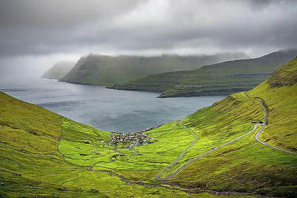 Storm clouds over the coastal village of Funningur along the fjord, Eysturoy Island, Faroe Islands, Denmark, Europe
