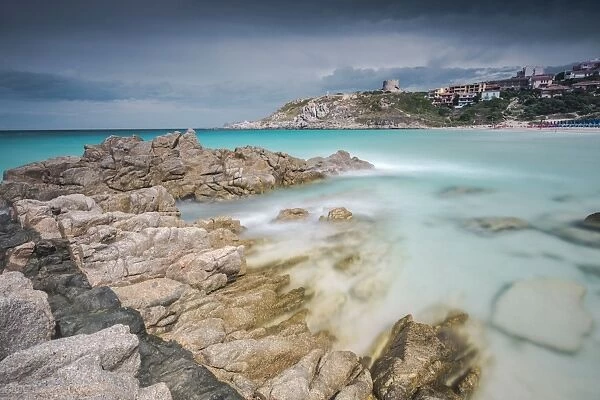 Storm clouds frame the village overlooking the turquoise sea, Santa Teresa di Gallura