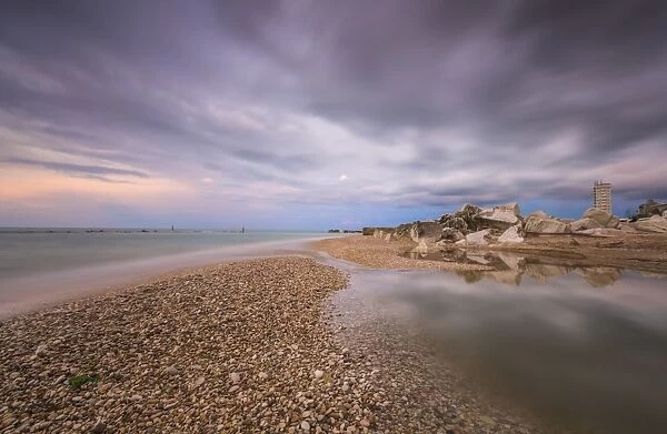 Storm clouds are reflected in the clear water at sunset, Porto Recanati, Province of Macerata