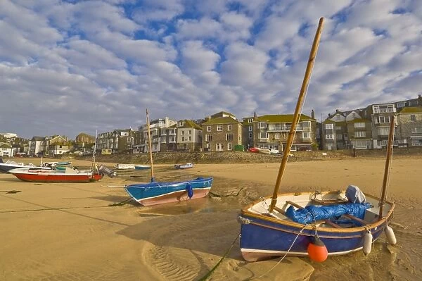 Strange cloud formation in the early morning with small Cornish fishing boats at low tide in the harbour at St. Ives, Cornwall, England, United