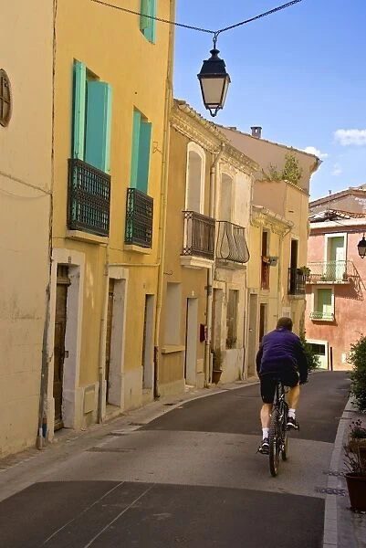 Street with cyclist, Old town, Bouzigues, Thau basin, Herault, Languedoc, France, Europe