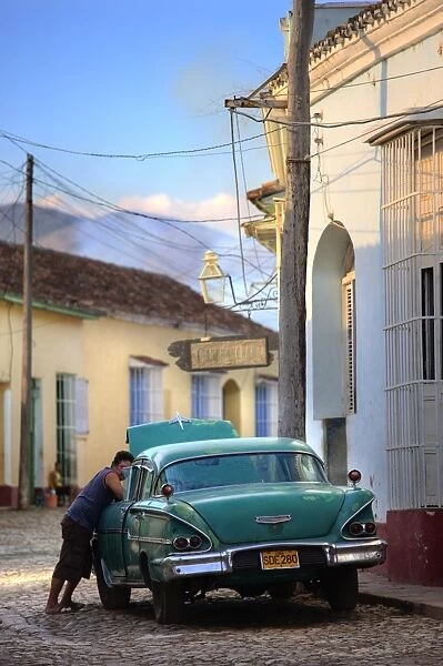 Street scene with colonial buildings and classic green American car, Trinidad
