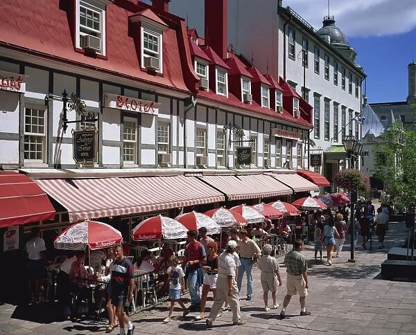 Street scene with hotel, restaurants and pavement cafes on Place d Armes in Quebec City
