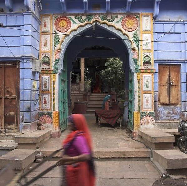 Street sweeper passing open porch of typical old haveli